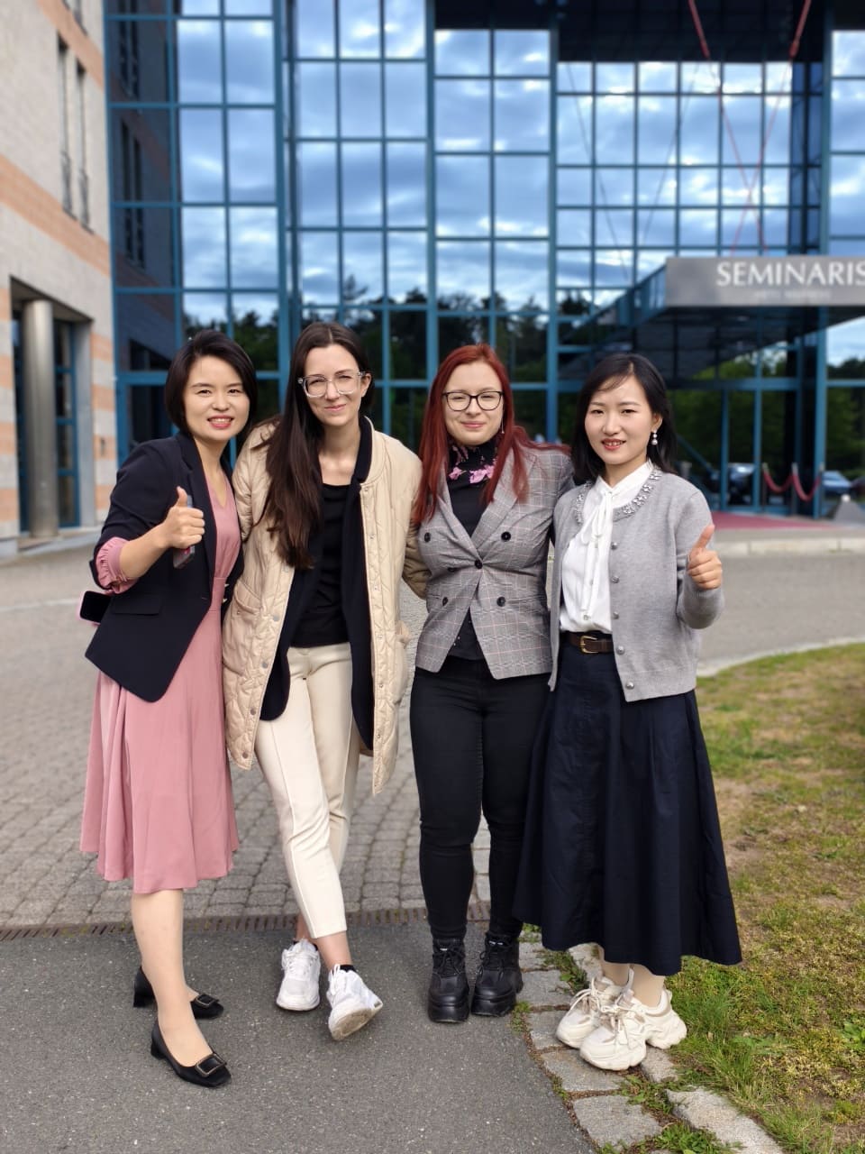 The Wellturn team visited overseas clients and took a group photo in front of the client's company